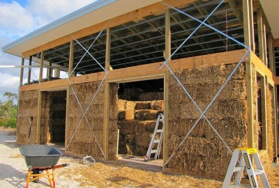 Mezi dřevěnou konstrukci obvodového obrysu domu se kladou slámové bloky, BrettCouls/Flickr.com